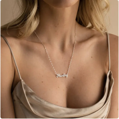 Necklace with 'Harley' pendant on a person wearing a beige top.